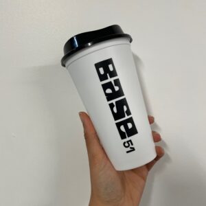Image of Base 51 branded travel cup. White cup, black logo and black lid.
