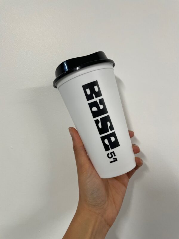 Image of Base 51 branded travel cup. White cup, black logo and black lid.
