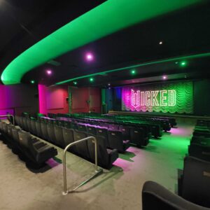 Cinema screen with Wicked projected onto it.