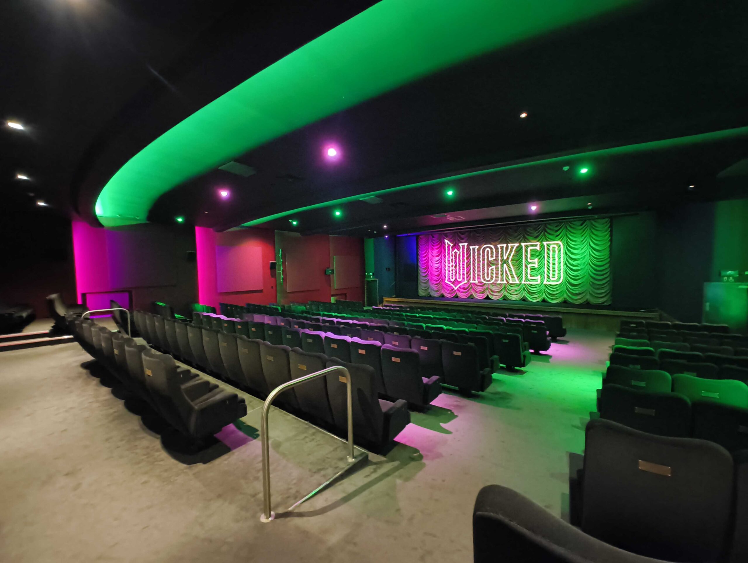 Cinema screen with Wicked projected onto it.